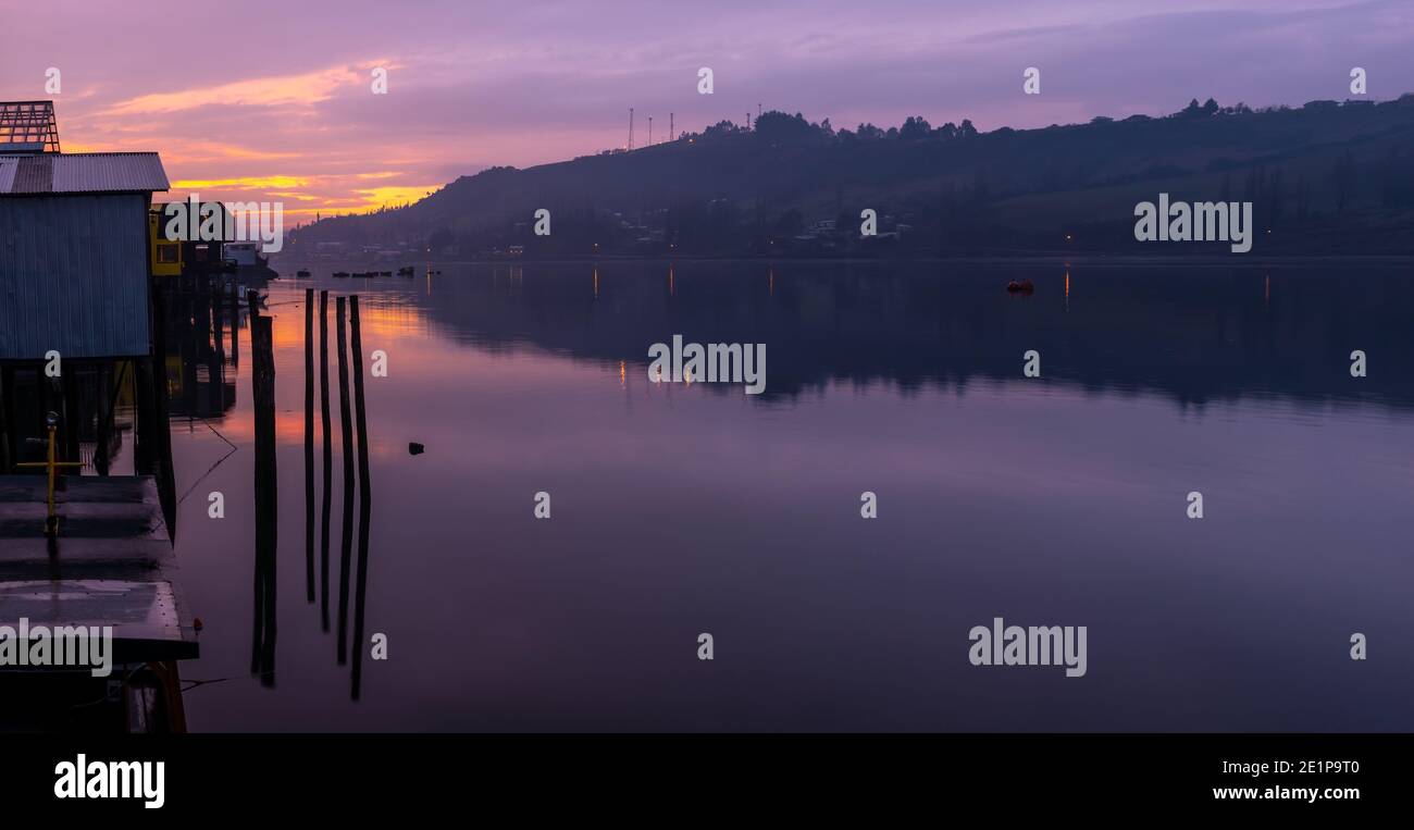 Sonnenuntergang in Castro Stadt entlang seiner Stelzenhäuser oder Palafitos, Chiloe Insel, Chile. Stockfoto
