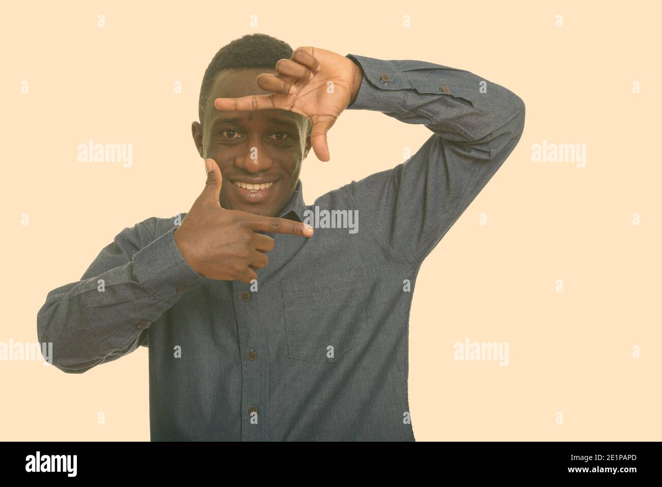 Junge glücklich afrikanischer Mann lächelnd und sich mit den Fingern Stockfoto