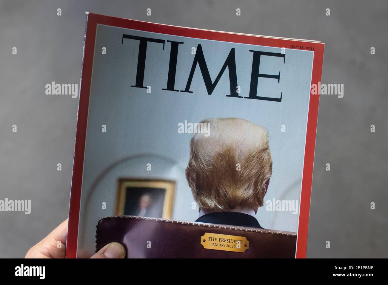 Hand mit einer 2016 Ausgabe des TIME Magazins mit Präsident Trump auf dem Cover. Stockfoto