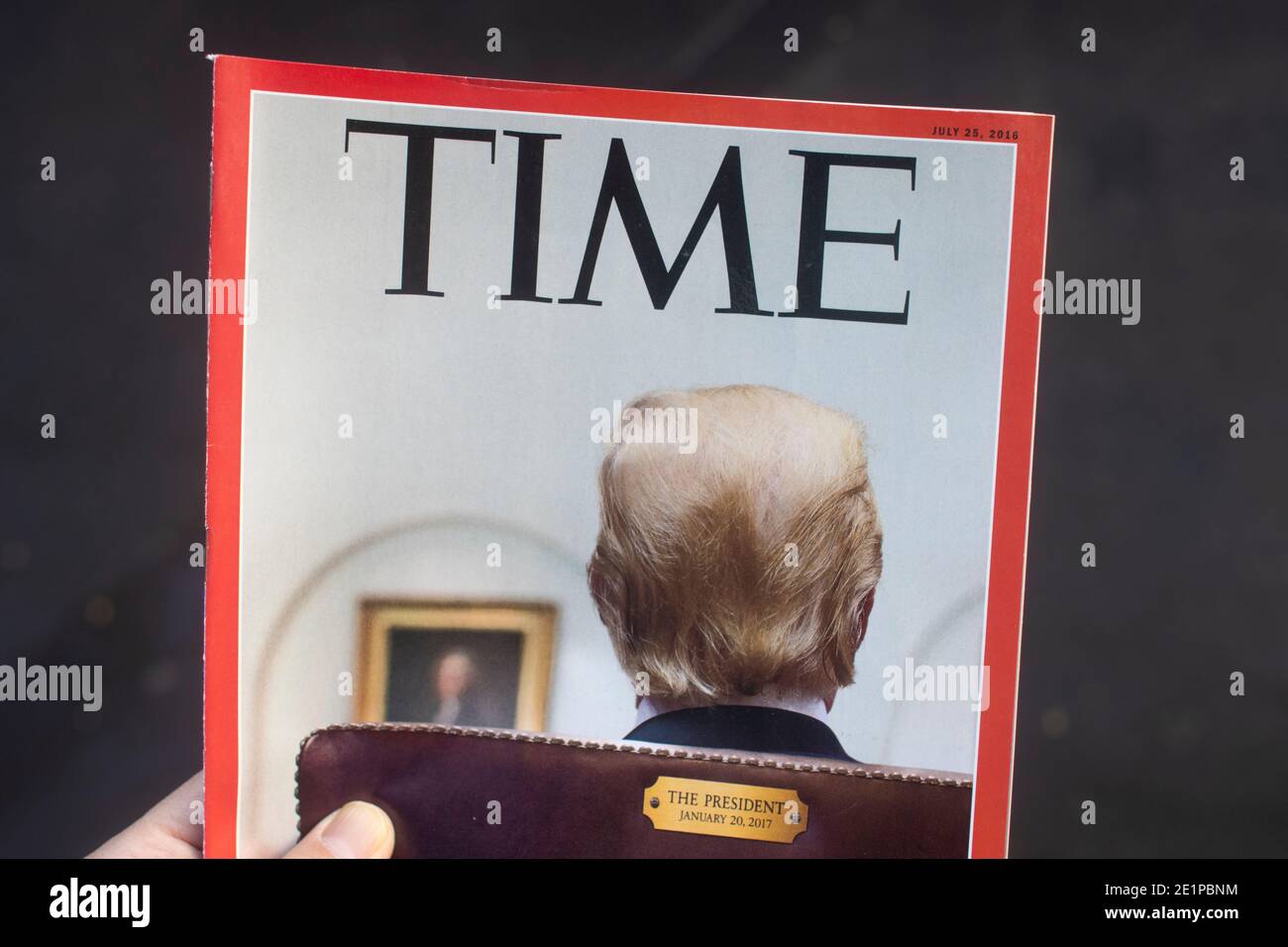 Hand mit einer 2016 Ausgabe des TIME Magazins mit Präsident Trump auf dem Cover. Stockfoto