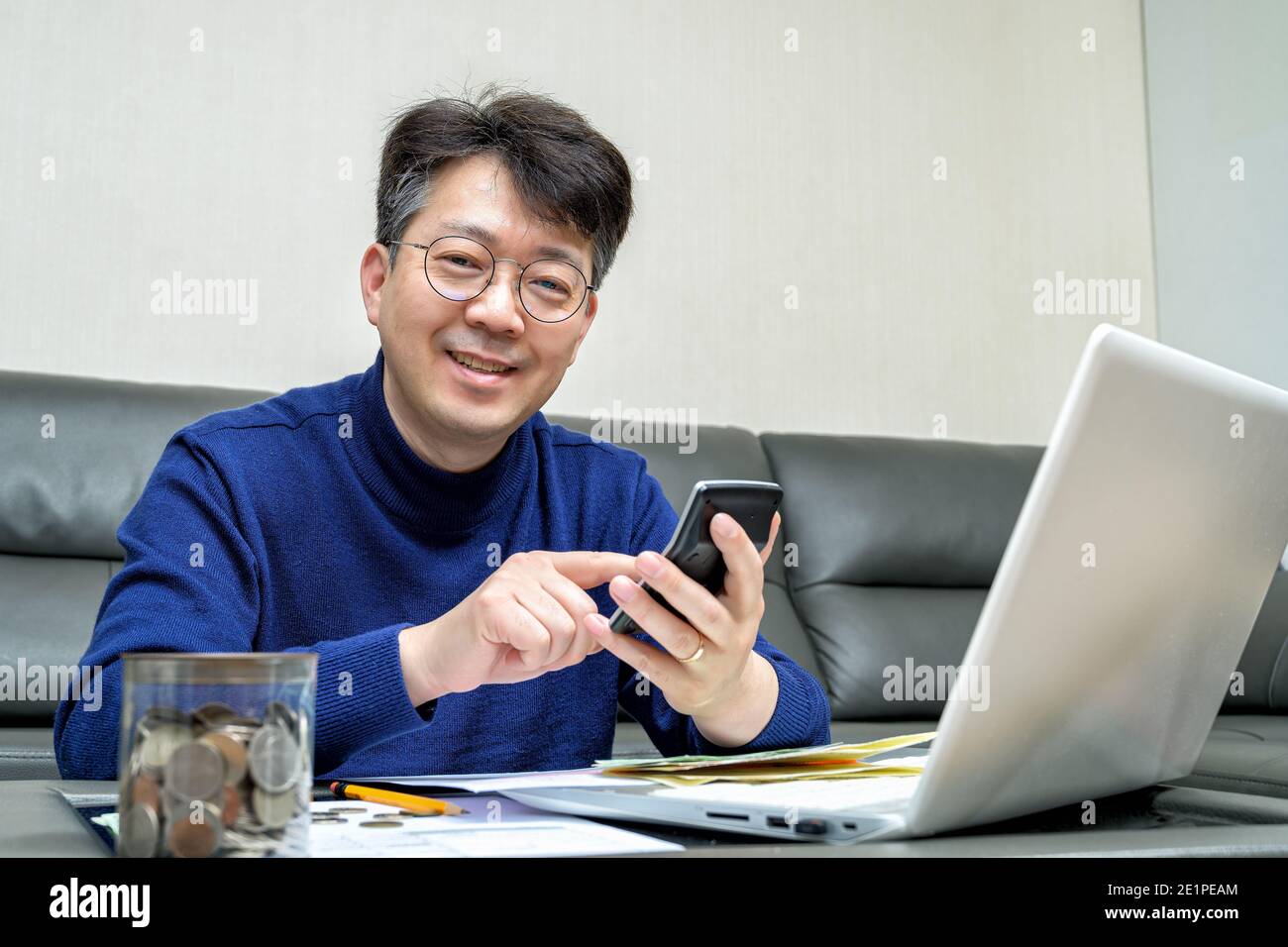 Asiatischer Mann mittleren Alters, der sich auf die Steuererklärung vorbereitet. Stockfoto