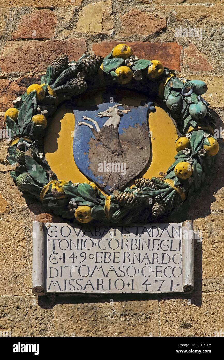 Hirsch auf einem emaillierten Terrakotta-Medaillon aus dem 15. Jahrhundert, ausgestellt auf dem Palazzo dei priori in Volterra, Toskana, Italien. Das Medaillon trägt das Wappen der florentinischen Kommissare Bernardo und Batista Corbinelli oder Corbinegli. Diese und ähnliche Medaillons, die die Fassade des Palastes besäßen, erinnern daran, wie 1452 die Medici Volterra eroberten und die Stadt von Florenz regiert wurde. Stockfoto