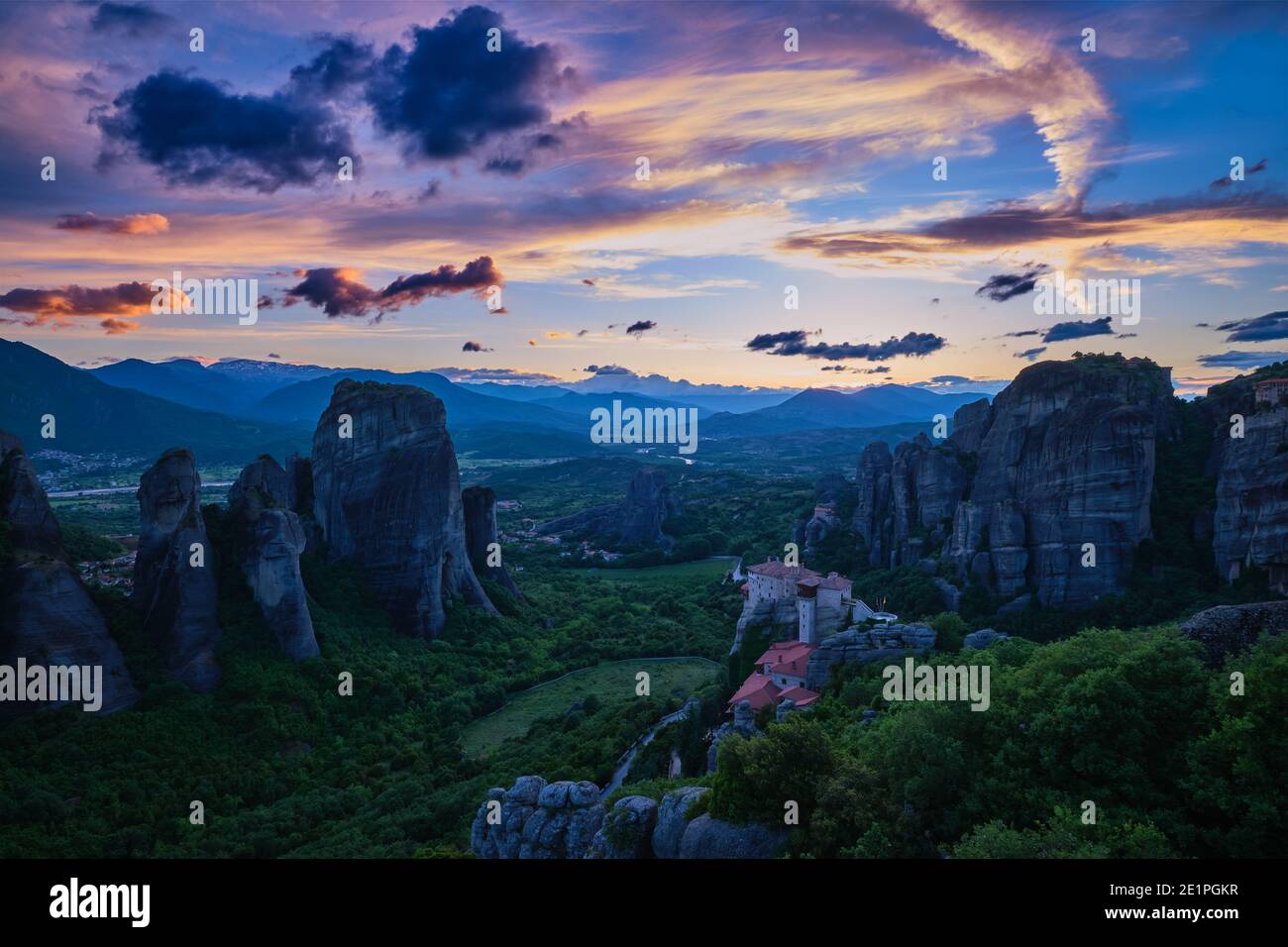 Blick in die Dämmerung auf das Meteora-Tal. Moni Agias Varvaras Roussanou Nonnenkloster, Felsen, Klippen. Schöner Himmel, bunte Wolken. Griechenland, UNESCO-Weltkulturerbe Stockfoto