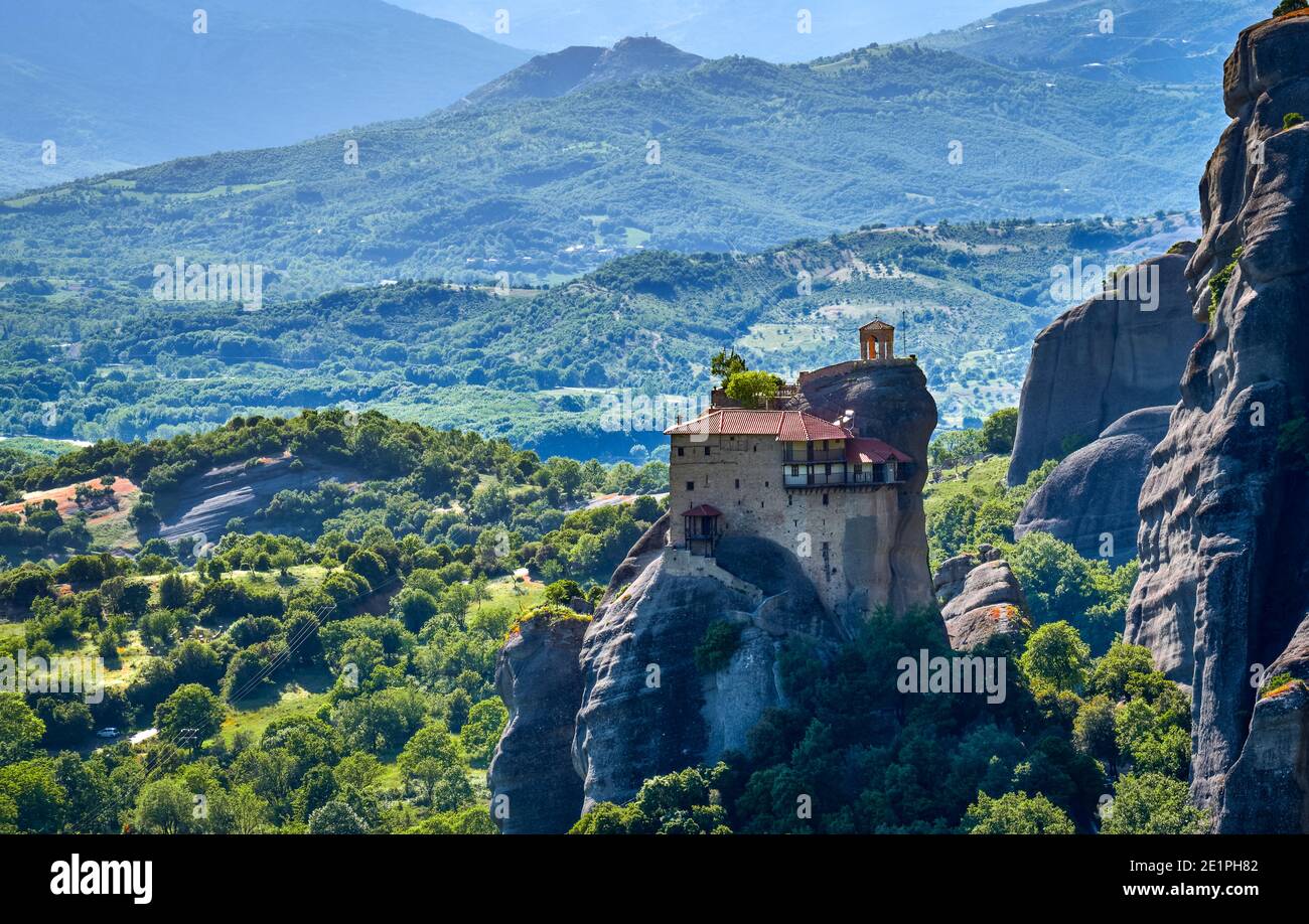 Nahansicht des Klosters St. Nicholaos Anapafsas auf der Spitze der sedimentären Säule, grüne Hügel des Meteora-Tals am Mittag. Griechenland, UNESCO-Weltkulturerbe Stockfoto