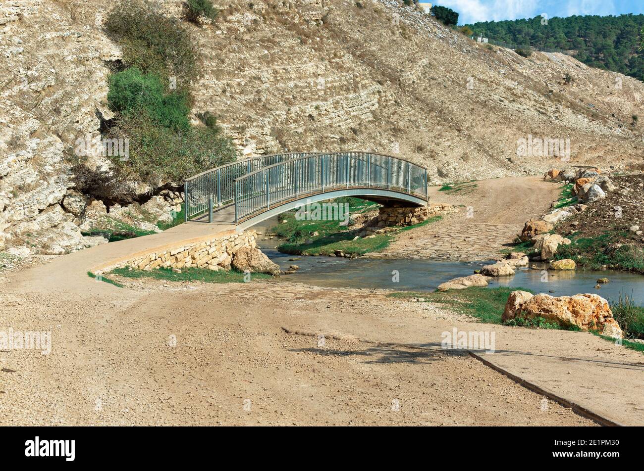 Fußgängerbrücke über den Fluss auf dem Hintergrund eines Steinberg in Israel Stockfoto