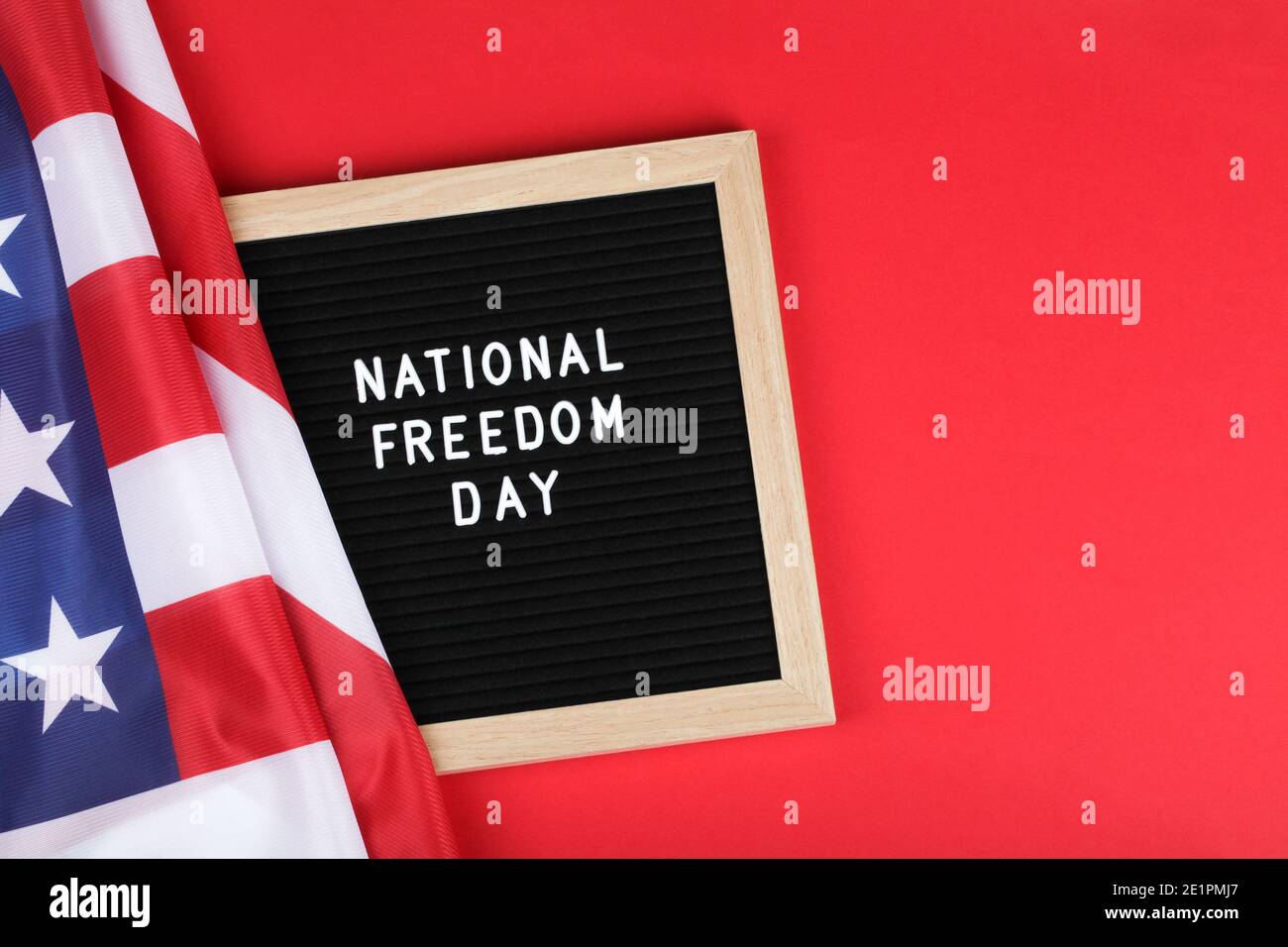 Schwarzes Briefbrett mit Text National Freedom day und amerikanische Flagge auf rotem Hintergrund. Draufsicht flach Lay Copy Space Stockfoto