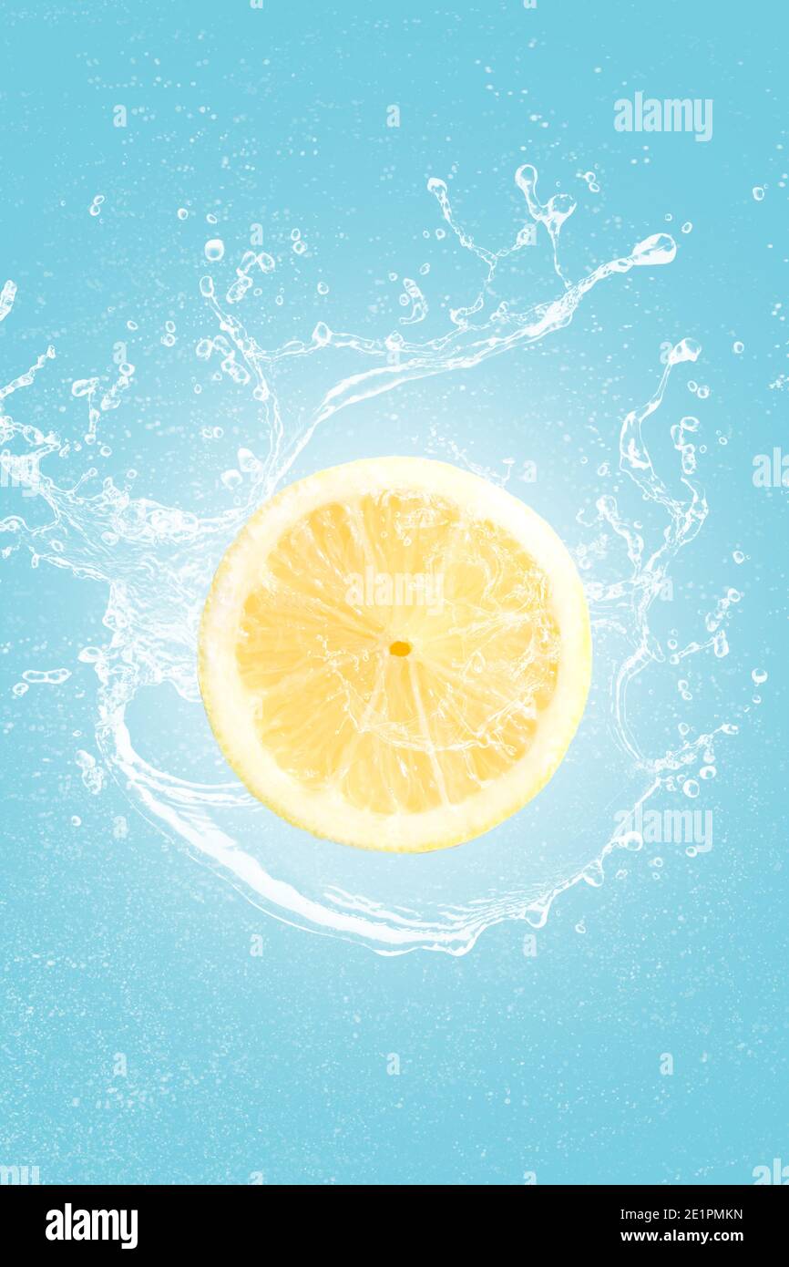 Zitronenscheibe mit Wasserspritzer isoliert auf blauem Schwarzboden. Stockfoto