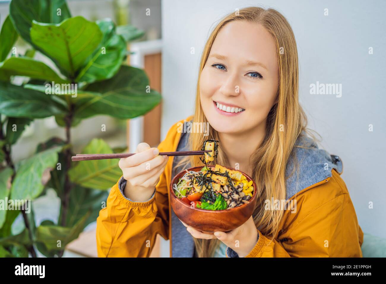 Frau, die rohe Bio-Poke-Schale mit Reis und Gemüse aus nächster Nähe auf dem Tisch isst. Draufsicht von oben horizontal Stockfoto