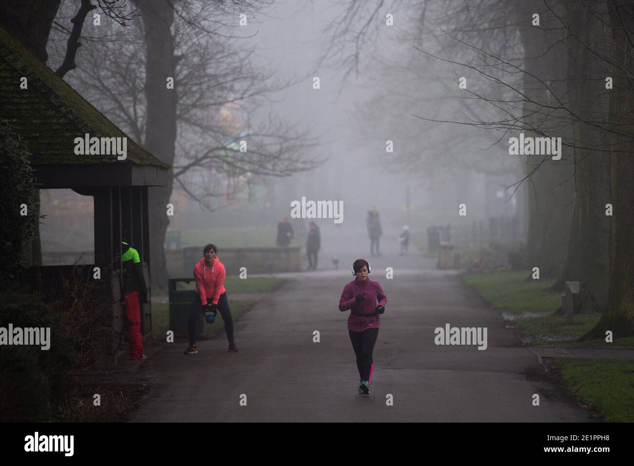 Heute Morgen trainieren die Menschen in einem kalten und nebligen St. Nicholas' Park in Warwick. Stockfoto