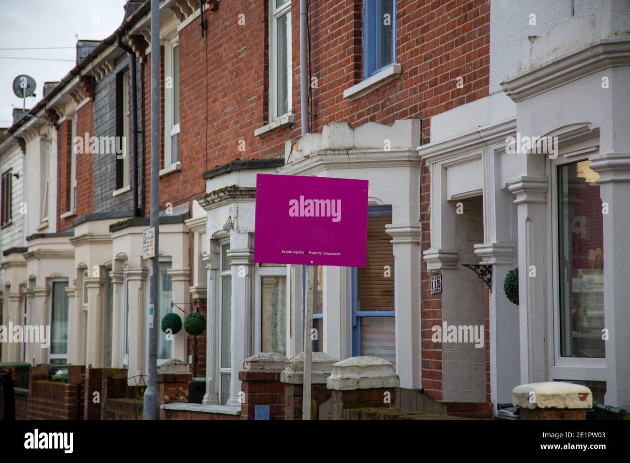 Ein Immobilienmakler Zeichen vor einer Reihe von britischen terrassenförmig Häuser Stockfoto