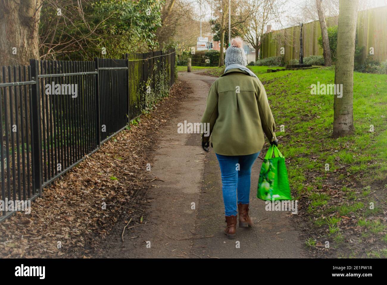 Eine Frau, die allein auf der Straße mit einem Einkaufsbummel geht Tasche Stockfoto