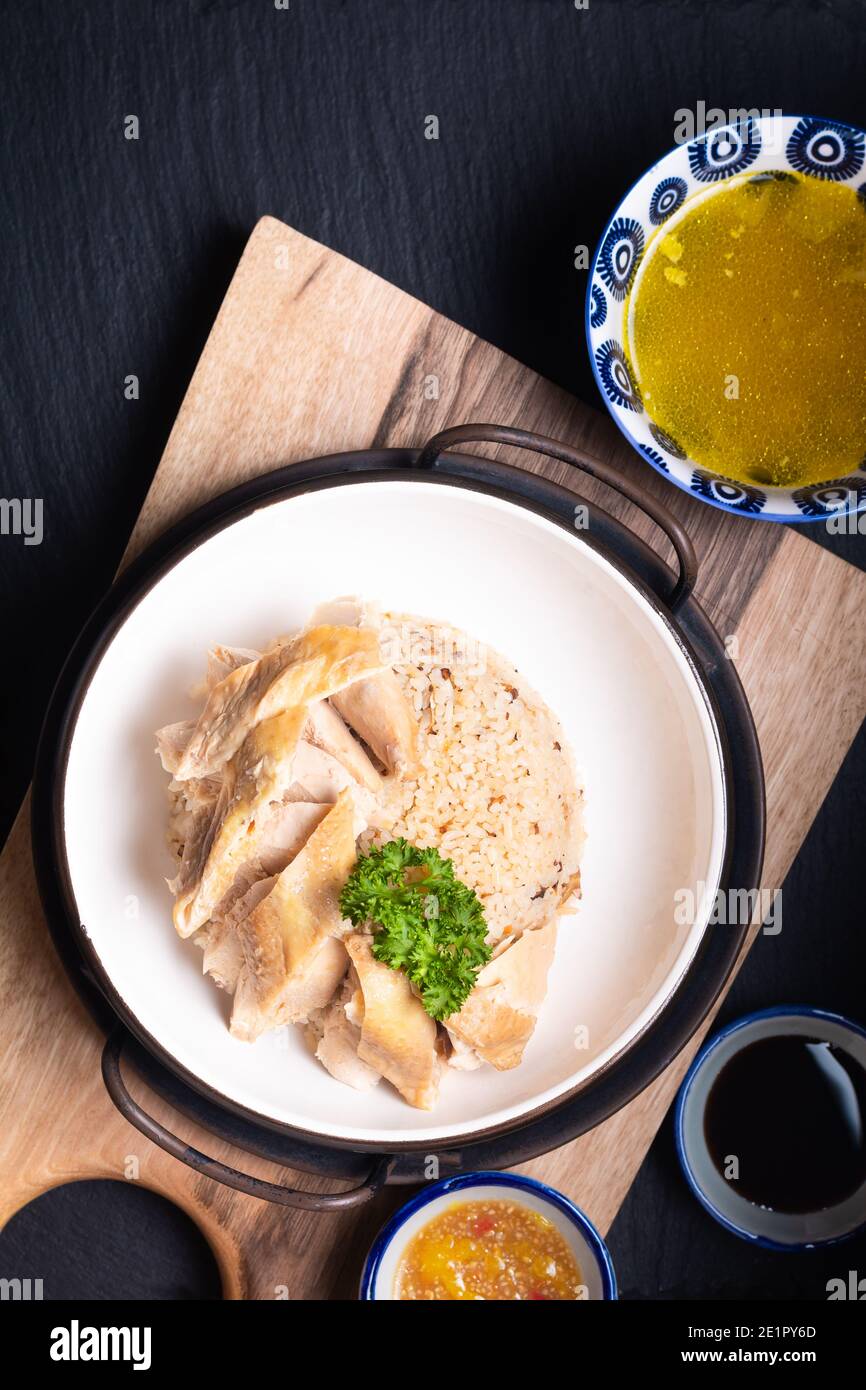 Asian Food Concept Hainanese Chicken Rice mit sauer und süß sojasauce auf Holzbrett mit Schieferstein Hintergrund Stockfoto