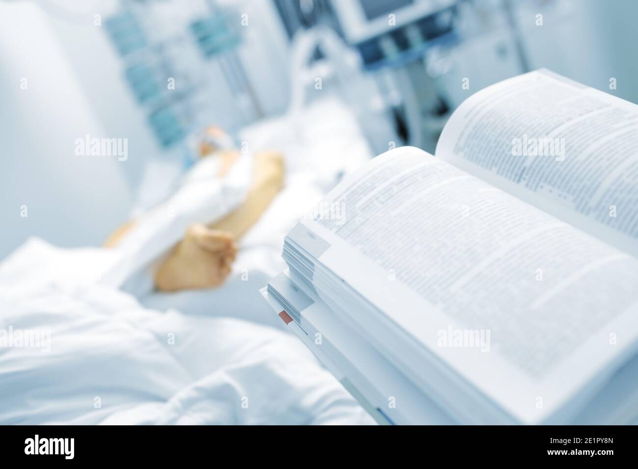 Öffnen Sie das Buch im Hintergrund des Patientenbetts. Symbol der medizinischen Ausbildung, Wissenschaft. Stockfoto