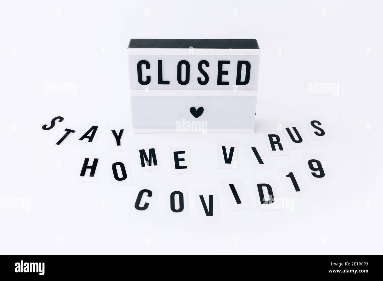 Konzept der Sperre, Covid 19. Text auf dem Display und Wörter zu Hause bleiben, Virus, Covid-19 verstreut um Leuchtkasten Stockfoto