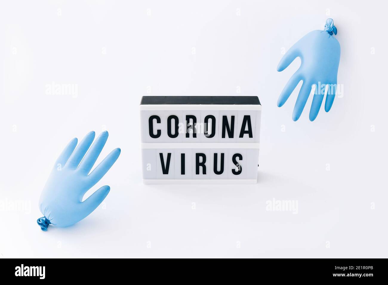 Covid-19 Globale Pandemie des Corona-Virus. Lightbox mit Text und Handschuhen Ballons auf hellem Hintergrund. Stockfoto