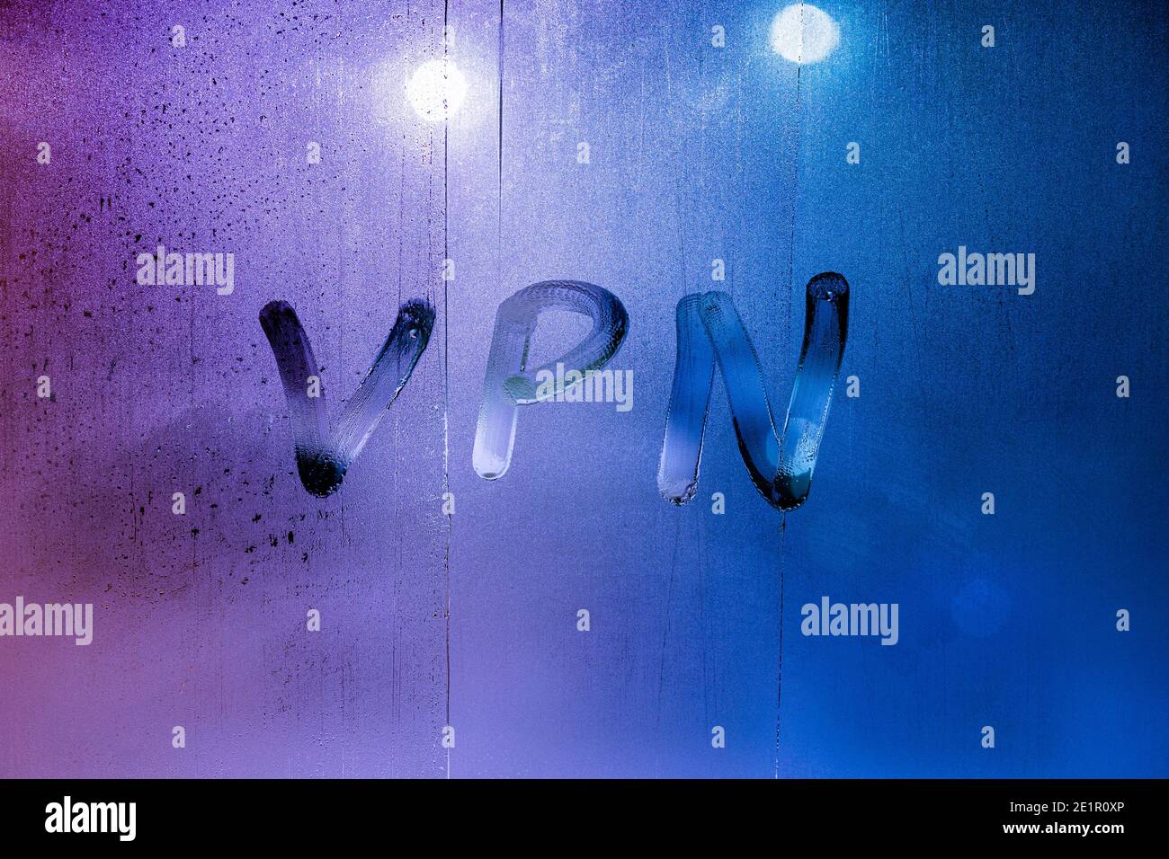 Eine Abkürzung VPN – virtuelles privates Netzwerk, das mit dem Finger auf nächtliches nasses Glas gezogen wird Stockfoto