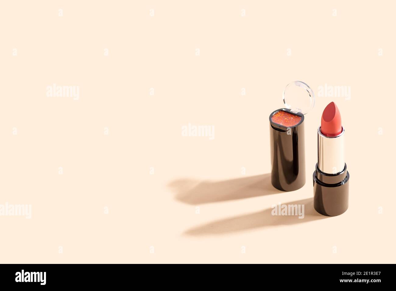 Roter Lippenstift auf beigem Hintergrund mit Kopierraum. Mode Blog Design. Stockfoto