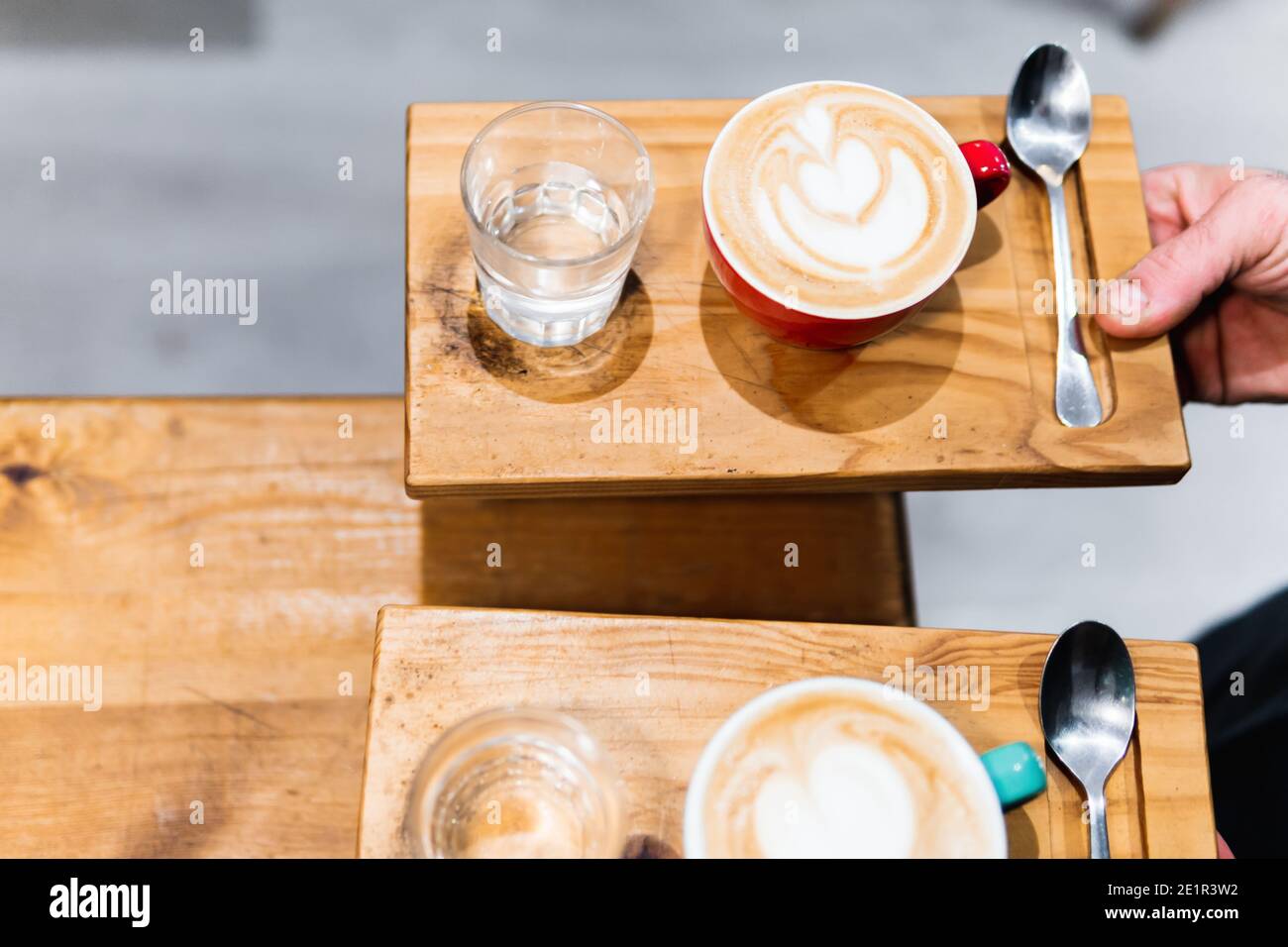 Zwei Tassen Cappuccino auf Holztabletts. Kaffee- und Kellnerkonzept Stockfoto