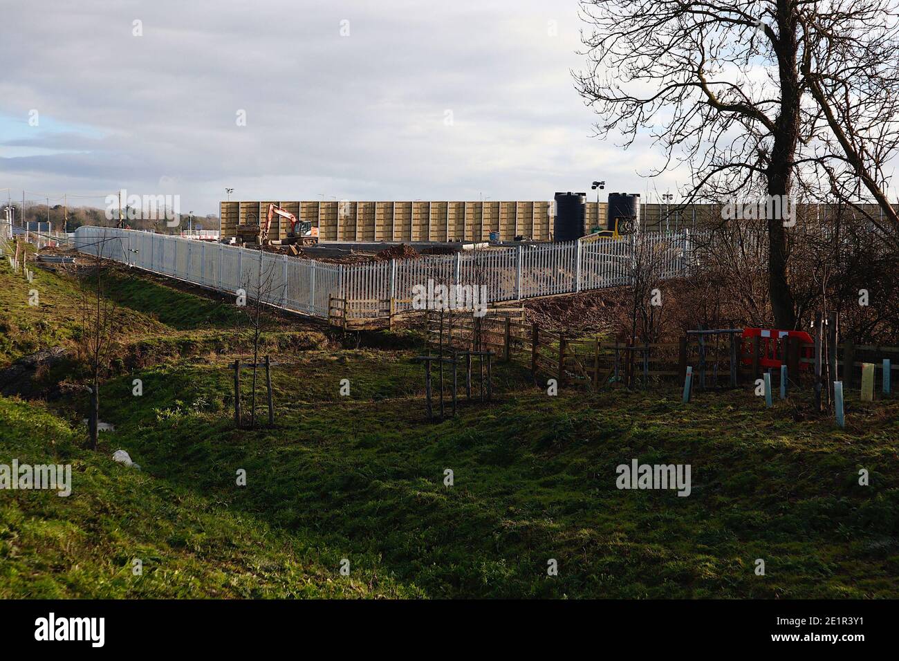 Ashford, Kent, Großbritannien. Januar 2021, 09. Die Binnengrenzfazilität von Sevington akzeptiert nun einen stetigen Strom von Lastkraftwagen, die die Kreuzung 10a, die von der Autobahn M20 abzweigt, zur Grenzkontrolle genommen haben. Um die Grenzanlage herum wird noch eine große Barriere errichtet. Foto-Kredit: Paul Lawrenson/Alamy Live Nachrichten Stockfoto