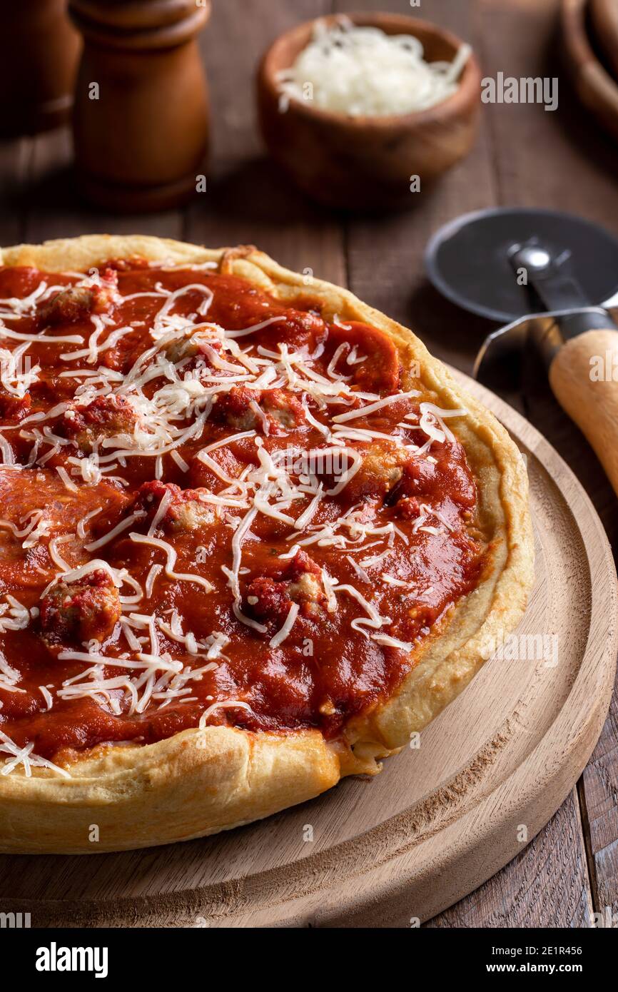 Köstliche Tiefgericht Wurst Pizza mit Mozzarella Käse auf einem Holzplatte Stockfoto