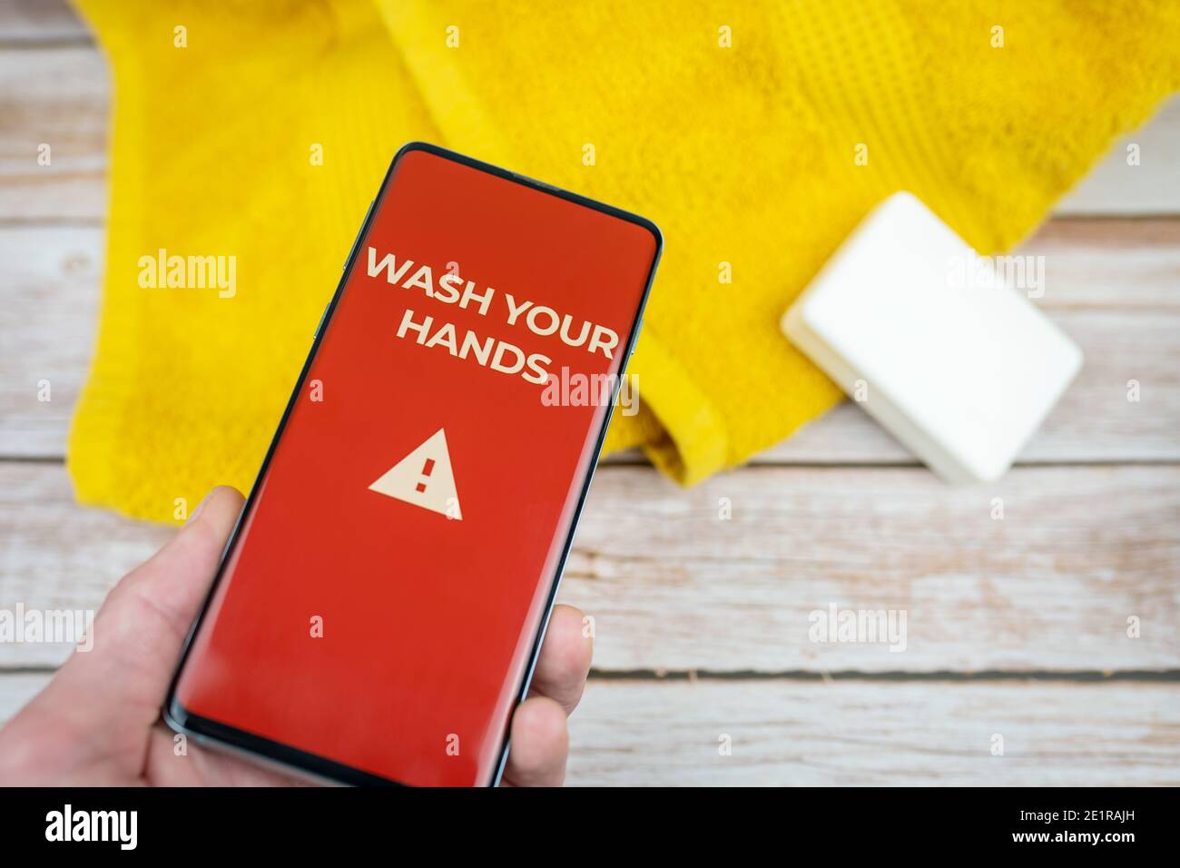 Waschen Sie Ihre Hände Zeichen auf rotem Hintergrund auf dem Smartphone angezeigt Schirm mit Seife und Handtuch Stockfoto