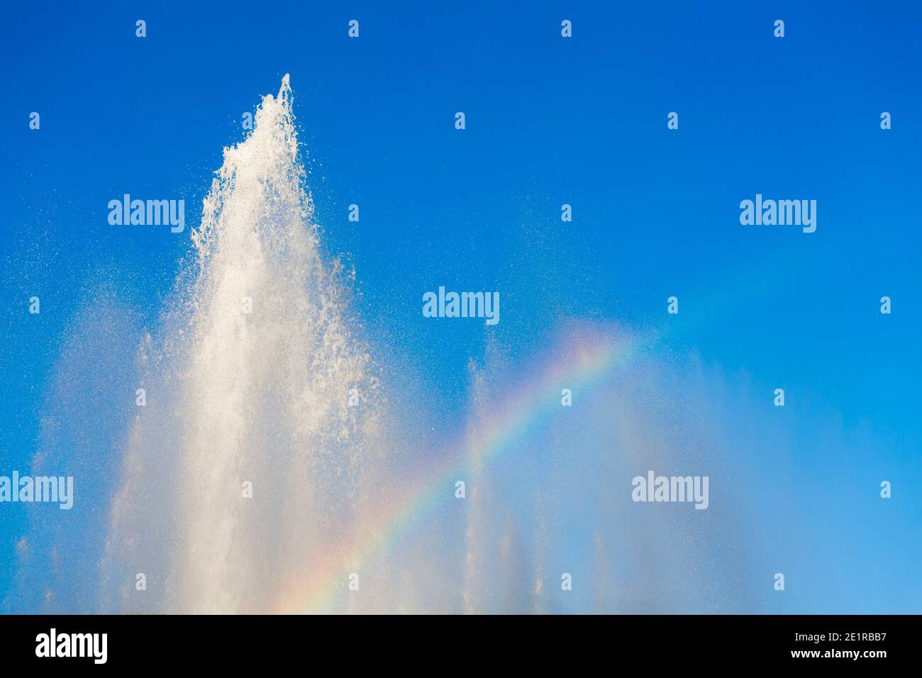 Regenbogenfarben und blauer Himmel im Brunnen am Schwarzenbergplatz in Wien, Österreich. Stockfoto