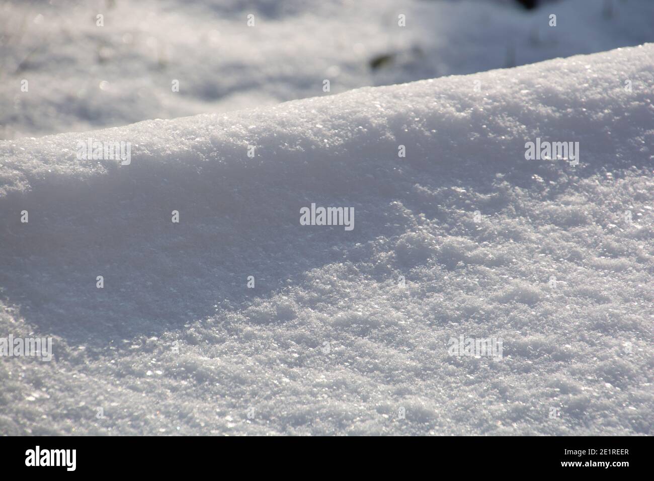 Schnee im Wintersonnenlicht mit Bokeh-Effekten und Lichtreflexionen Nahaufnahme Stockfoto