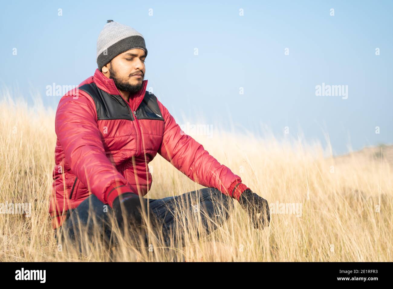 Reisende meditieren auf dem Gipfel des Berges während des kalten Morgens - Konzept der Verbindung mit der Natur, Erleuchtung und Achtsamkeit Stockfoto