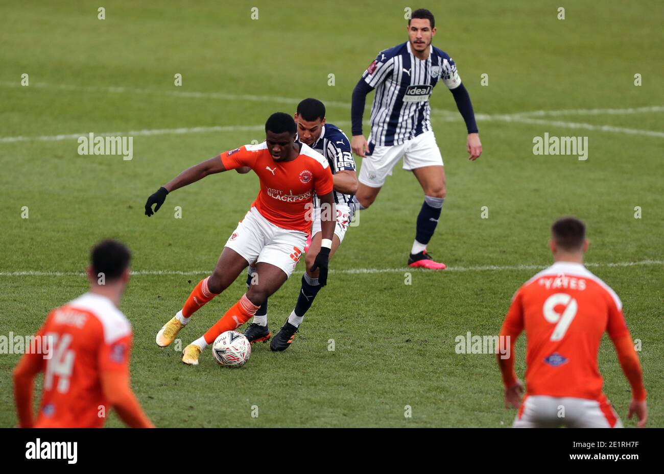 Beryly Lubala (vorne) von Blackpool kommt von West Bromwich Lee Peltier von Albion während des Emirates FA Cup dritten Runde Spiel in Bloomfield Road, Blackpool. Stockfoto