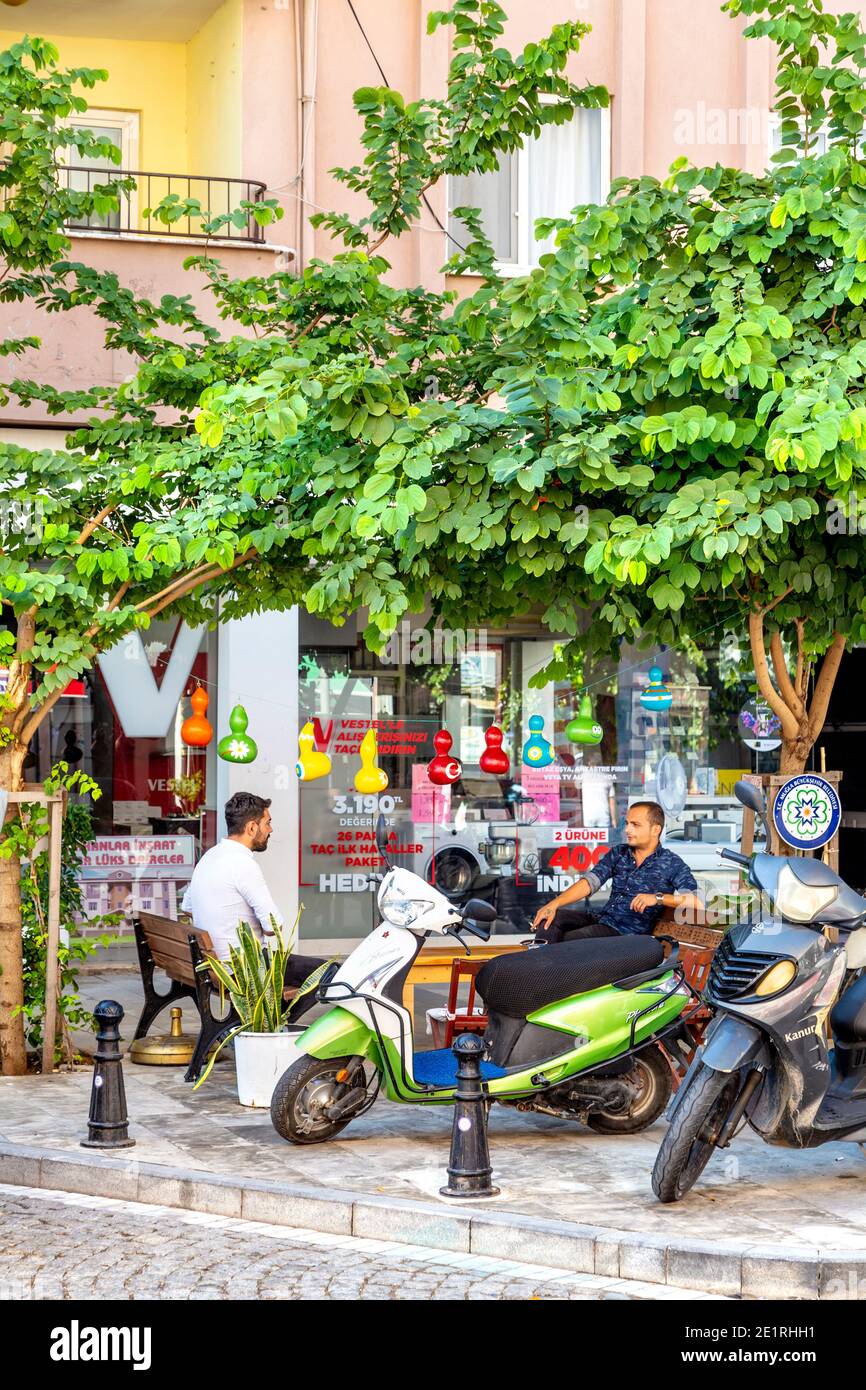 Geparkte Motorroller und ein Mann, der sich draußen in Dalaman, Türkei, unterhielt Stockfoto