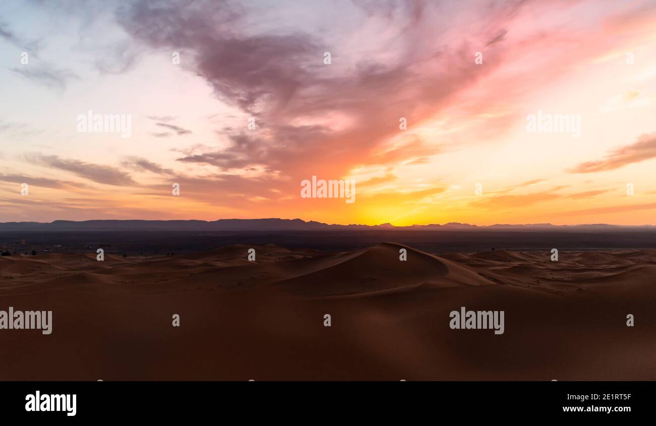 (Selektiver Fokus) atemberaubende Aussicht auf einige Sanddünen bei Sonnenuntergang beleuchtet. Merzouga, Marokko. Natürlicher Hintergrund mit Kopierbereich. Stockfoto