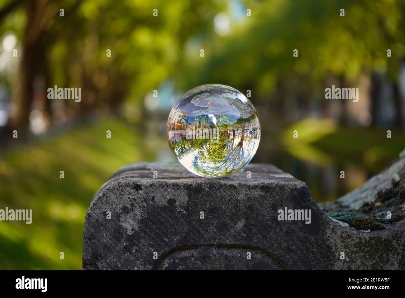 Der schöne grüne Stadtkanal (Kö-Graben) an der Königsallee mit Spiegelung der Landschaft in einer Glaskugel. Stockfoto