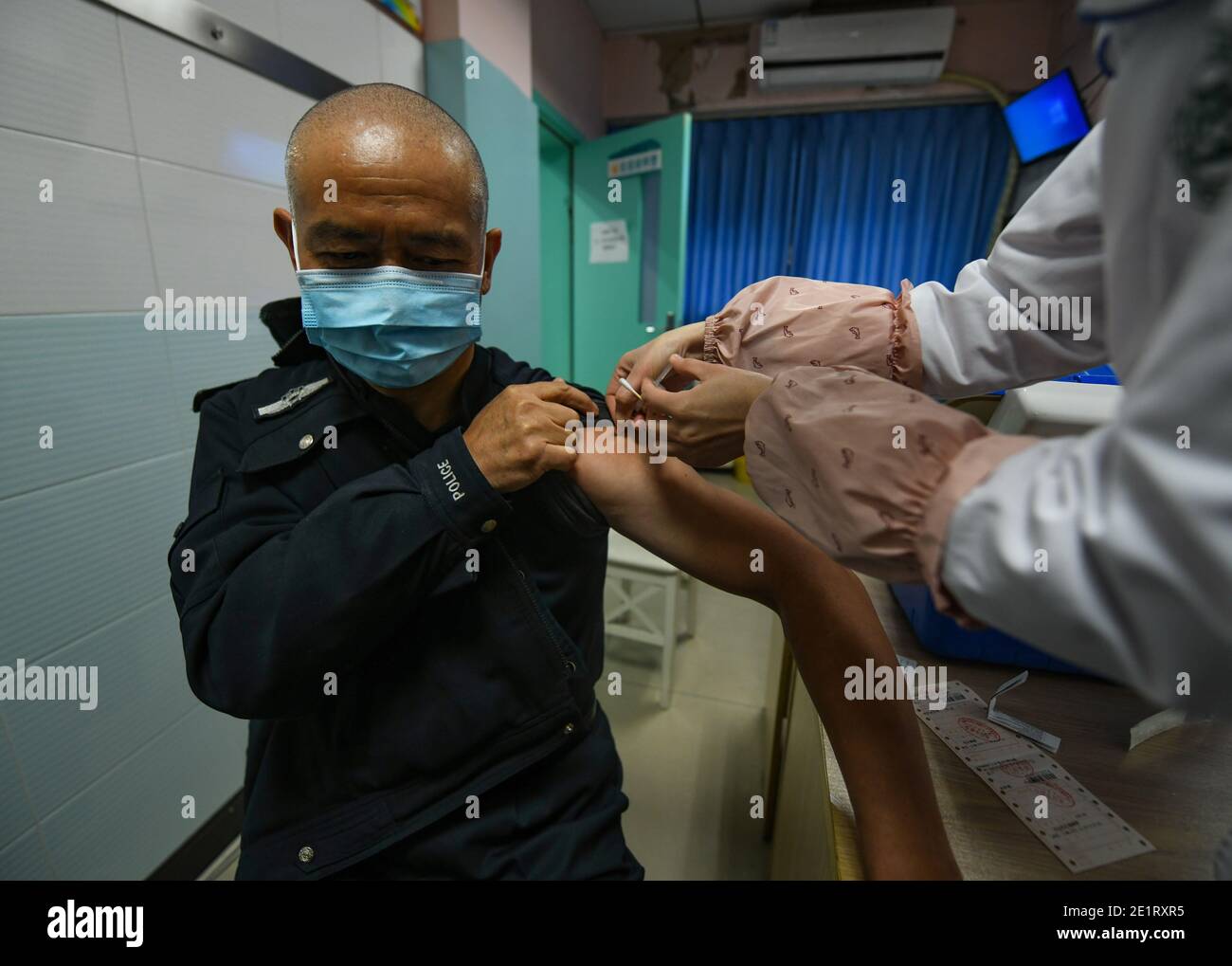 Chengdu, Sichuan, China. Januar 2021. Qiao Zhibing erhält COVID-19-Impfung im Shuangnan Gesundheitszentrum in Chengdu, südwestlich der chinesischen Provinz Sichuan, 8. Januar 2021. Am 10. Januar 2021 ist Chinas erster Tag der chinesischen Volkspolizei, Doch für Qiao Zhibing, einen 59-jährigen Polizisten der Jiangxi Straßenpolizeiwache der Wuhou Bezirksniederlassung des Büros für Öffentliche Sicherheit in Chengdu, wird es sein "letzter" Polizeitag sein, da er im Juni dieses Jahres im Alter von 60 Jahren in den Ruhestand gehen wird. Quelle: Xinhua/Alamy Live News Stockfoto
