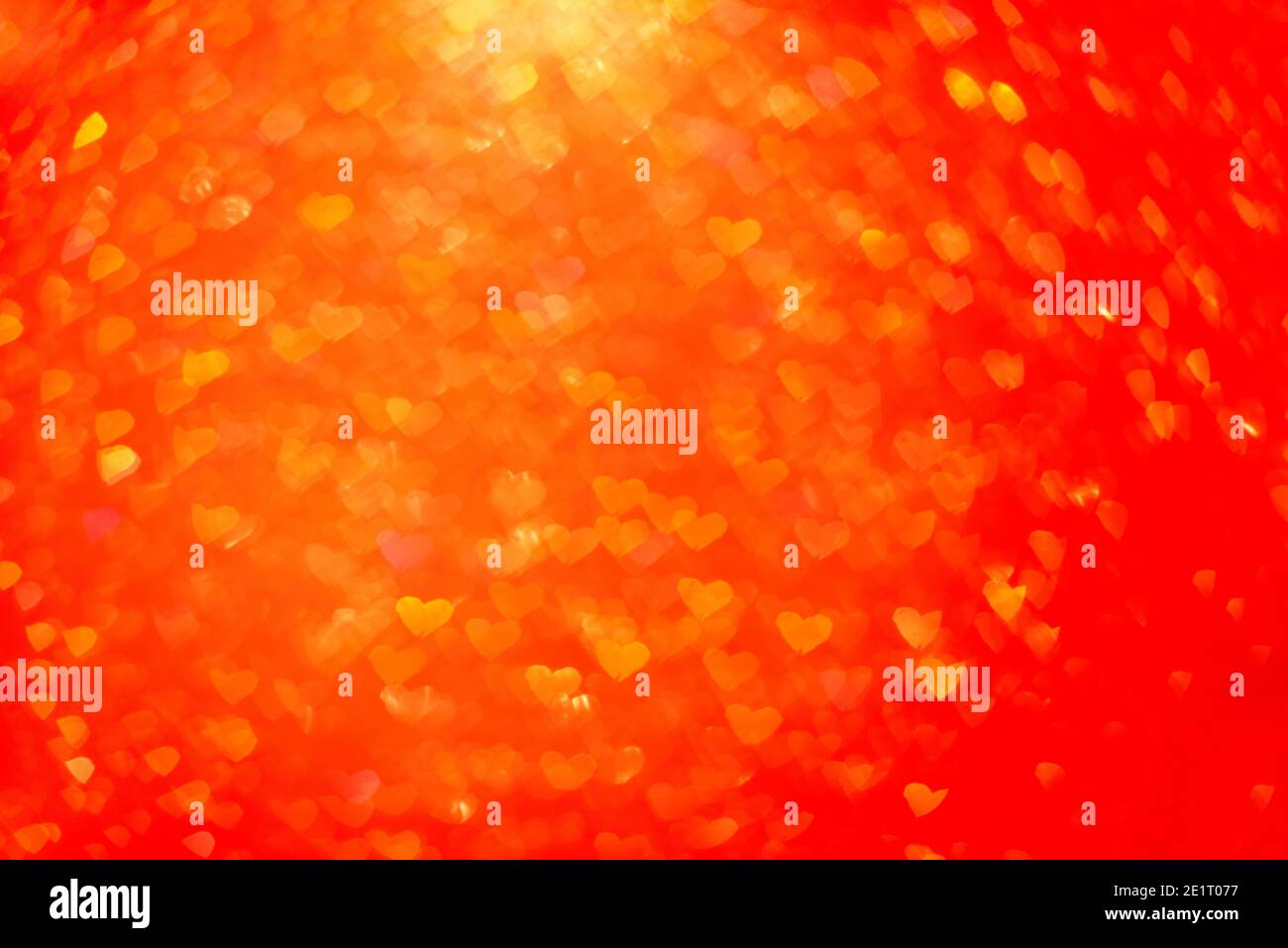 Unscharfer Bokeh-Hintergrund. Textur aus rot orangenen Herzen. Vorbereitung auf eine Weihnachtskarte. Abstrakter Valentinstag, festliche Liebe Stockfoto