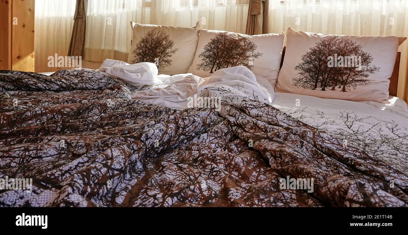 Bett am Morgen in einem gemütlichen Schlafzimmer entkleiden Stockfoto