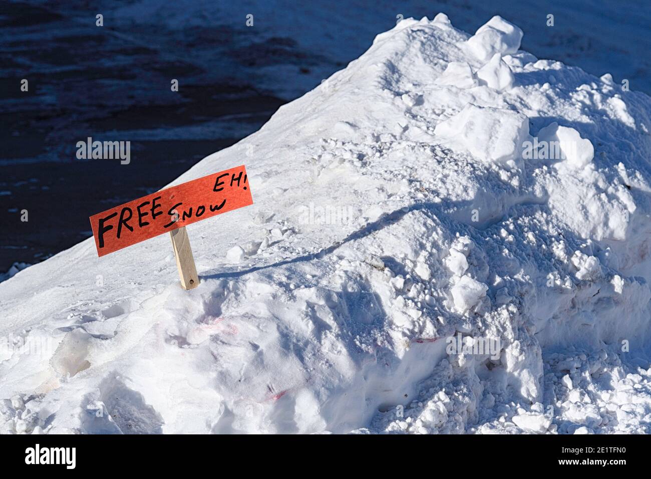 Schneeräumung mit einem lustigen Schild, das freien Schnee verschenkt Stockfoto