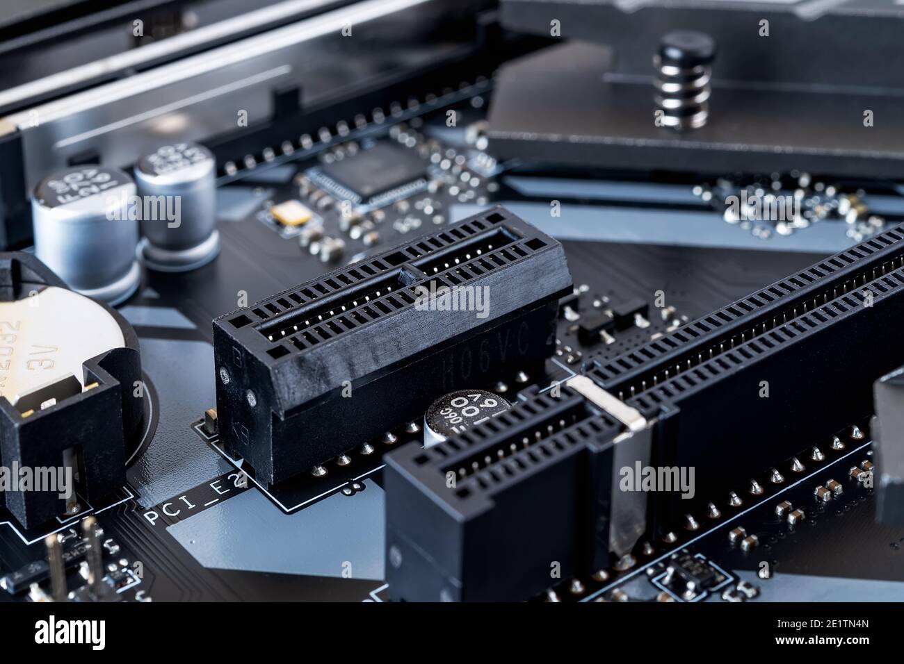 PCI-E Erweiterungssteckplatz auf einem modernen schwarzen Mainboard. Komponenten der Hauptplatine des Computers. Nahaufnahme der Desktop-Hardware. Makro PC-Komponenten. Stockfoto
