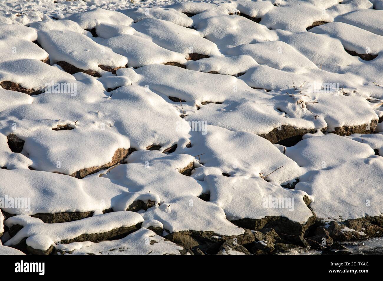 Schnee auf Ufersteinen in Helsinki, Finnland Stockfoto