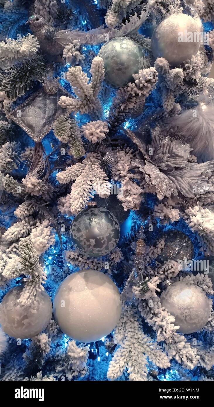 Künstlicher Weihnachtsbaum mit Kugeln und blauen Lichtern, Fragment Stockfoto