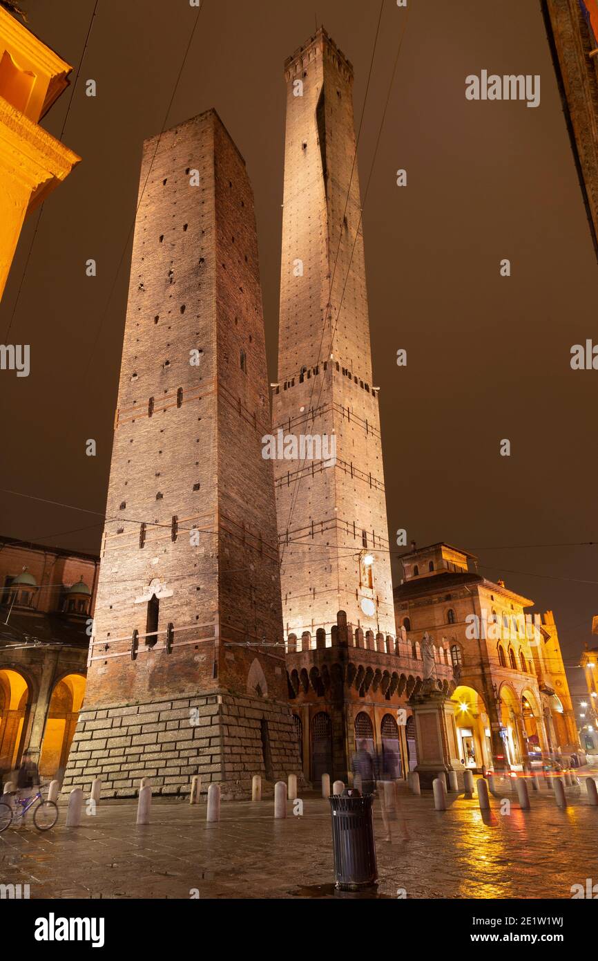 Bologna - die Türme Torre della Garisenda und Torre della Asinelli und Platz Piazza della Mercanzia bei Nacht Stockfoto
