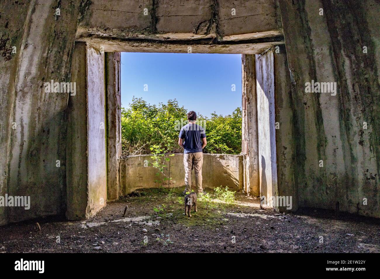 Der Mensch denkt nach Frieden und schaut aus dem verlassenen Bunkerfenster, Albanien. Die Bunker der kommunistischen Ära wurden von Diktator Enver Hoxha während des Kalten Krieges gebaut. Stockfoto
