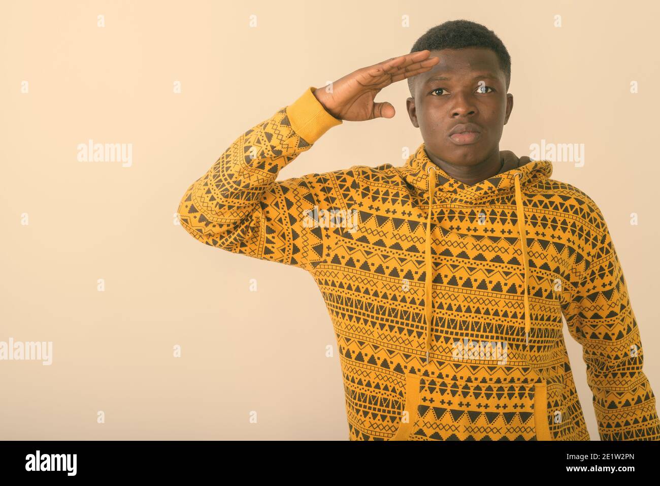 Studio shot von jungen schwarzen afrikanischen Mann salutierte vor weißem Hintergrund Stockfoto