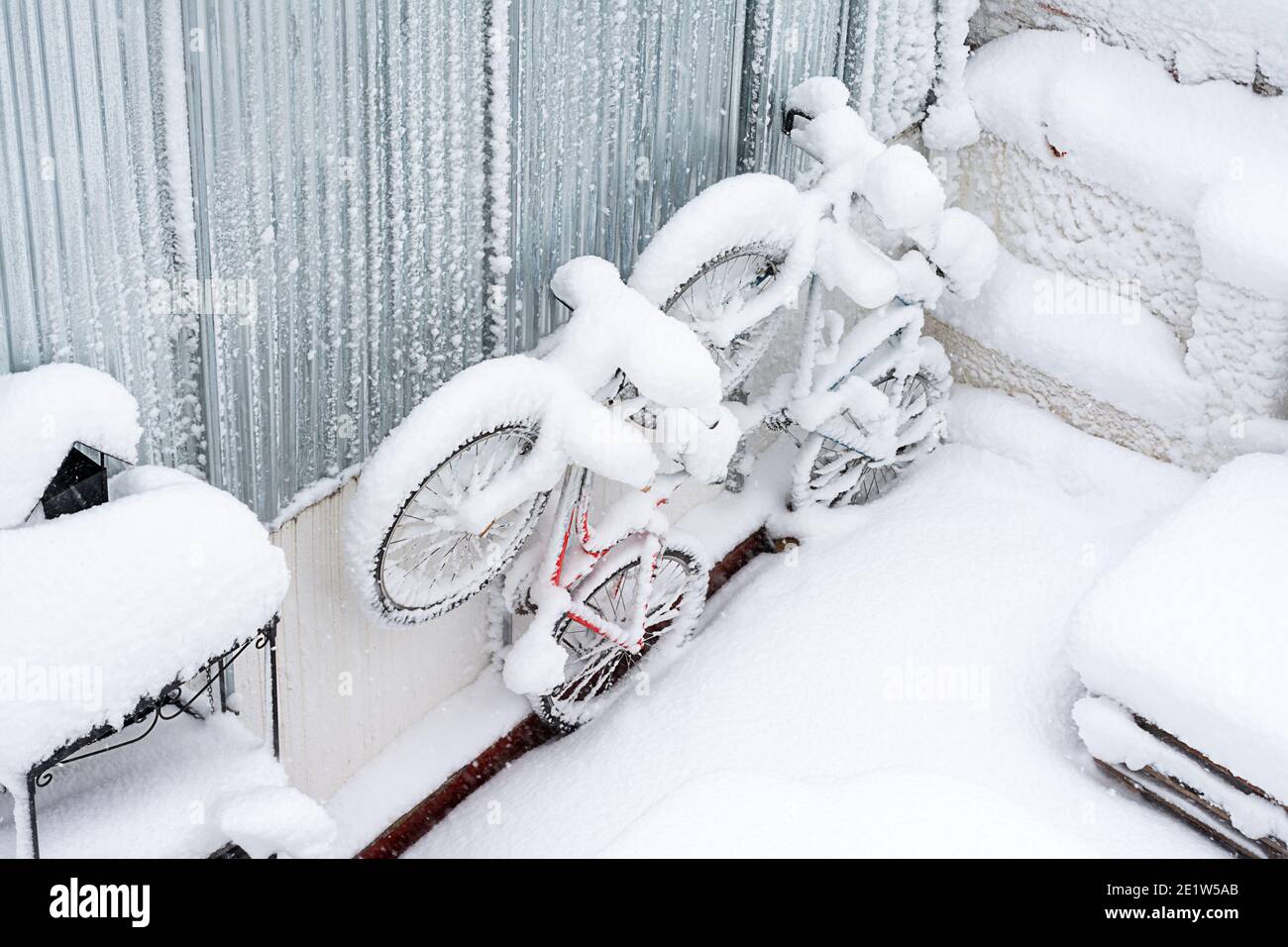 Schneebedeckte Fahrräder im Hinterhof eines Hauses, Winterwetter, Prognose Stockfoto
