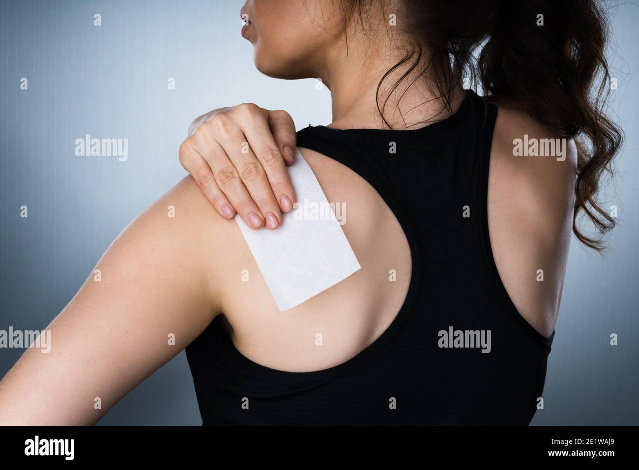 Frau Anwendung Steifer Schulterschmerzen Pflaster Nach Verletzung Stockfoto
