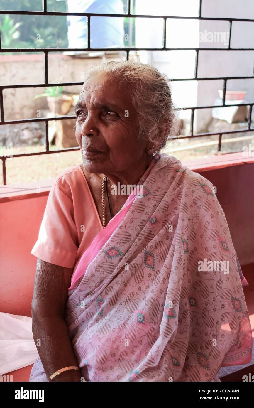 Alte schöne indische Frau Oma in einem Sari auf der Bank sitzen. Stockfoto