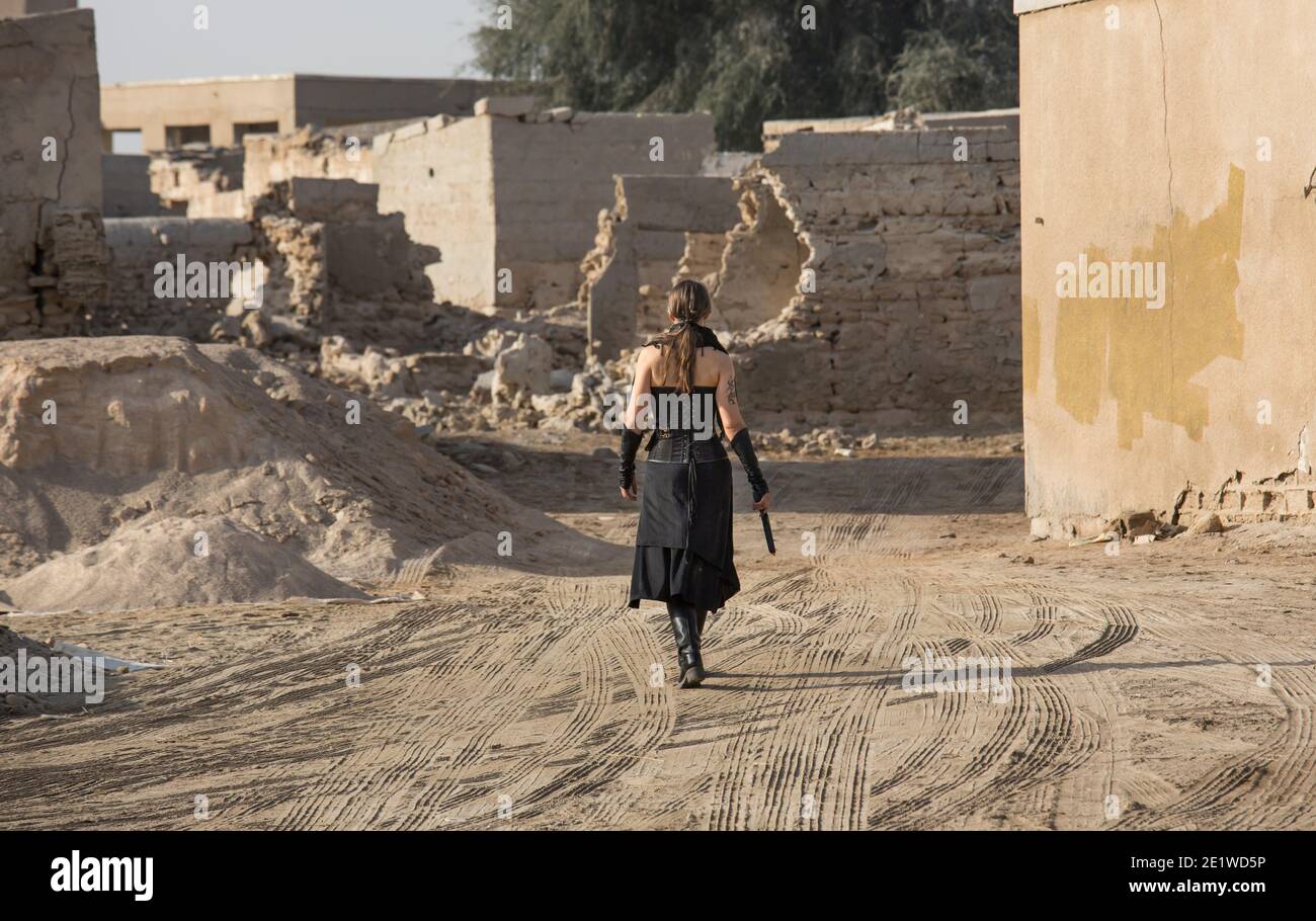 Frau mittleren Alters trägt Steampunk Kostüm der Freiheit Kämpfer in Ihr altes zerstörtes Dorf Stockfoto