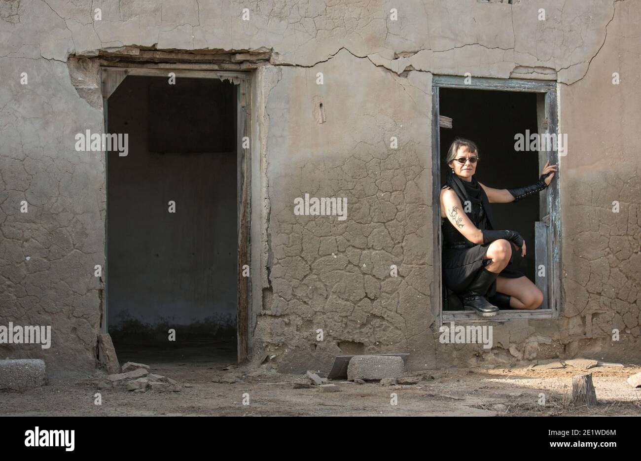 Frau mittleren Alters trägt Steampunk Kostüm der Freiheit Kämpfer in Ihr altes zerstörtes Dorf Stockfoto