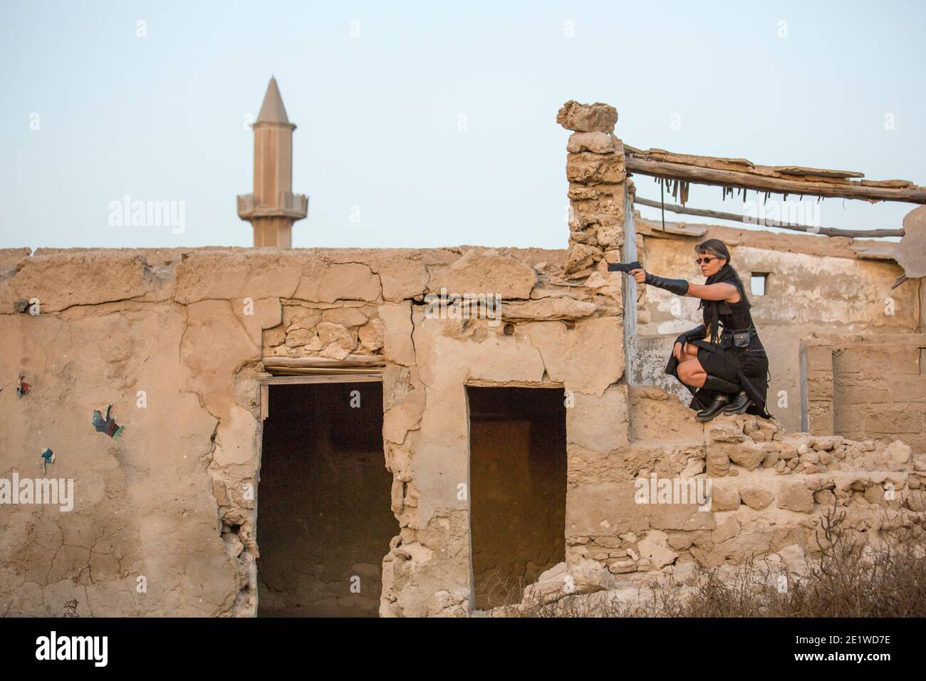Frau mittleren Alters trägt Steampunk Kostüm der Freiheit Kämpfer in Ihr altes zerstörtes Dorf Stockfoto