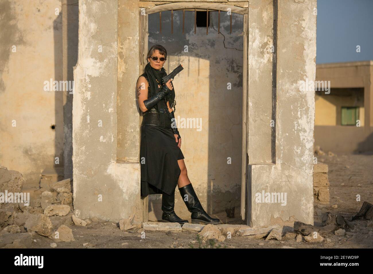 Frau mittleren Alters trägt Steampunk Kostüm der Freiheit Kämpfer in Ihr altes zerstörtes Dorf Stockfoto