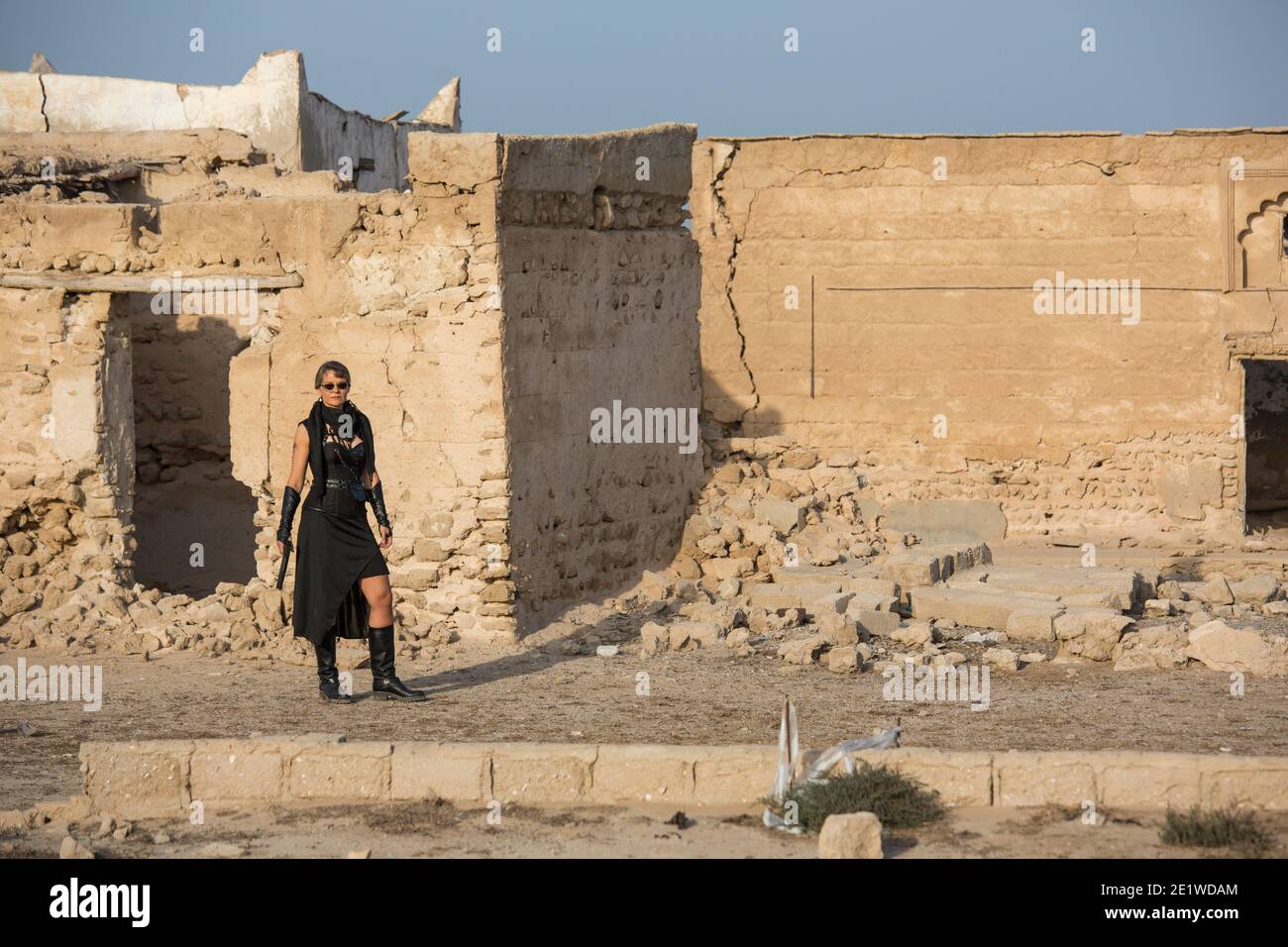Frau mittleren Alters trägt Steampunk Kostüm der Freiheit Kämpfer in Ihr altes zerstörtes Dorf Stockfoto